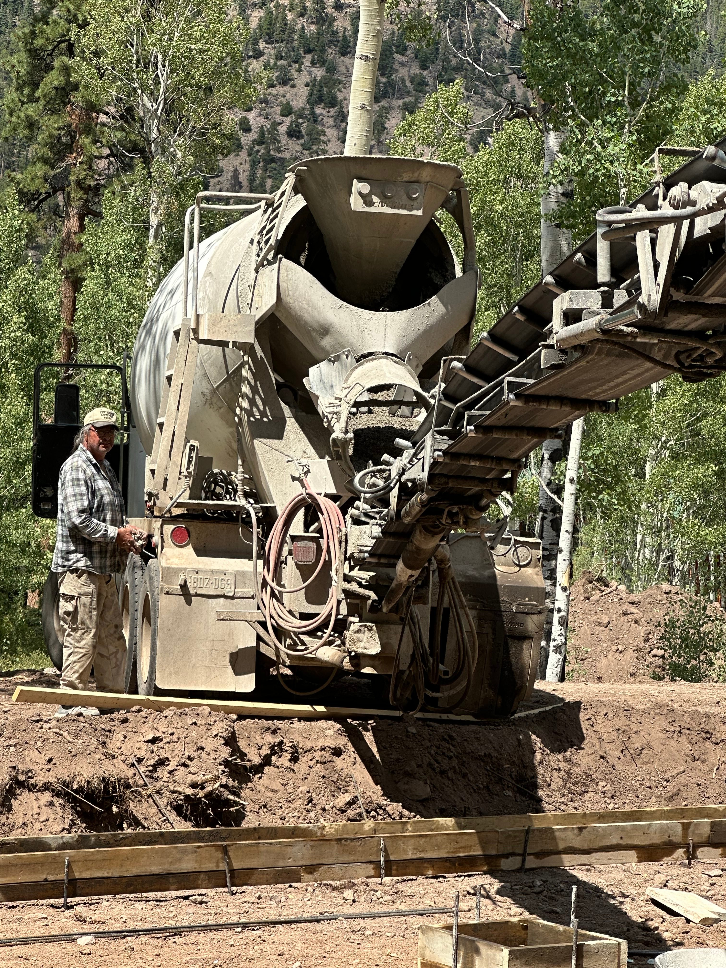 Mixer truck operator with conveyor in an aspen grove